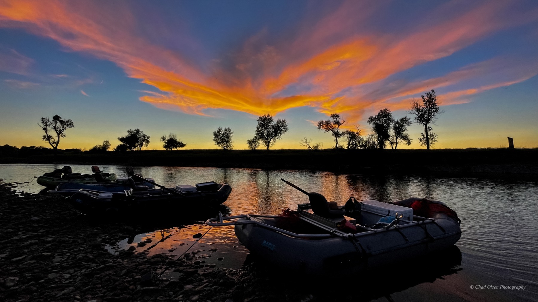 Sun River sunset with two fully rigged inflatable rafts parked on the shoreline