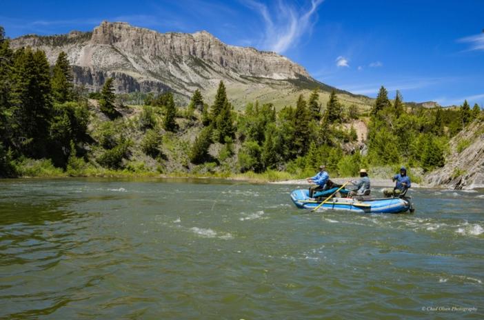 Rafting down a rocky river with mountains in the background